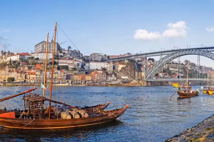 Barcos de Rabelo no Douro com a Ponte Luís I e o Porto ao fundo.