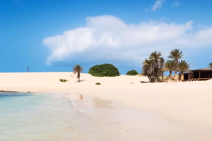 Praia de Chaves em Boa Vista, com areia branca, água turquesa e uma duna.