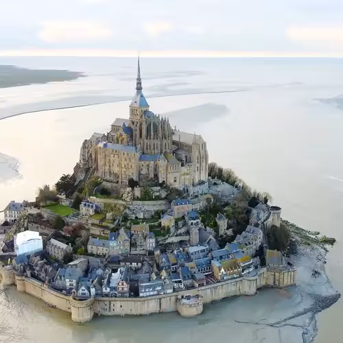 Aerial view of Mont-Saint-Michel, with the abbey, the walls and the village on the rock surrounded by the bay