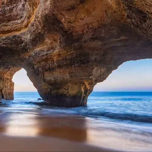 Stunning view of the iconic Benagil Sea Cave with turquoise waters and dramatic rock formations in the Algarve region of Portugal.
