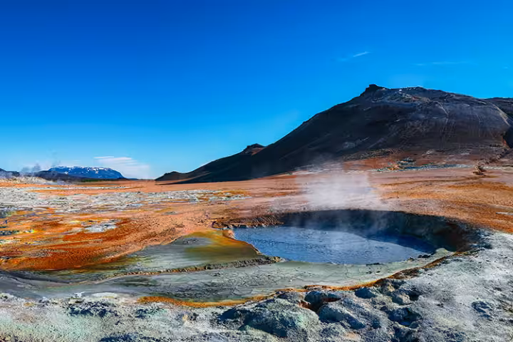 Steaming geothermal hot springs and colorful sulfuric landscape at Námafjall Hverir in Iceland, one of the best natural wonders to explore during a winter Iceland tour.
