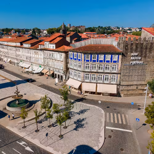 Il centro storico di Guimarães, in Portogallo, vanta un'affascinante architettura tradizionale con facciate decorate da colorate piastrelle, ideale per esplorare il patrimonio culturale e godersi la vivace vita di strada.