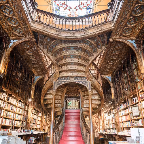 A histórica Livraria Lello, no Porto, Portugal, com sua icônica escadaria vermelha e interior ornamentado em madeira, é uma atração imperdível na região dos Clérigos e do Norte.