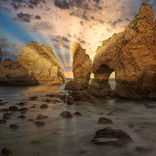 Pôr do sol sobre as deslumbrantes formações rochosas da Ponta da Piedade, na região do Algarve, Portugal, exibindo a beleza natural da área e a paisagem costeira dramática.