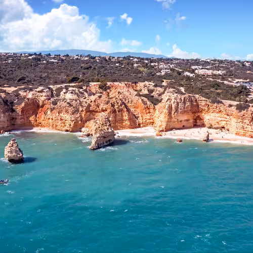 A breathtaking view of the stunning Praia da Marinha with its golden cliffs and turquoise waters, a must-visit spot in Lagoa, Algarve, Portugal.