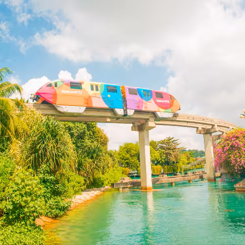 La coloratissima monorotaia Sentosa Express attraversa una vegetazione lussureggiante e fiori dai colori vivaci sull'isola di Sentosa, a Singapore.