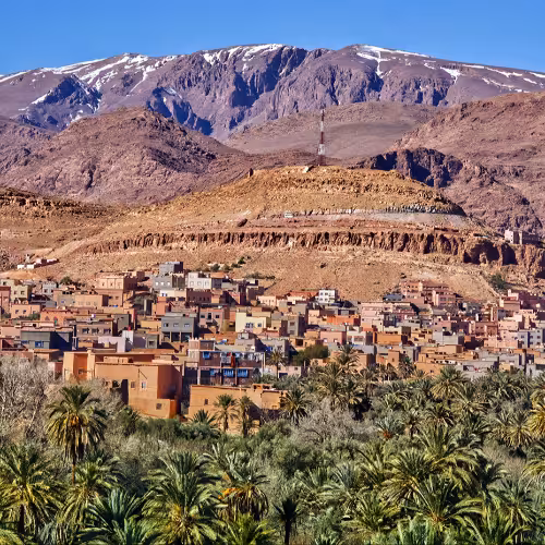 Vista panorámica de Tinghir en Drâa-Tafilalet, Marruecos, con un exuberante oasis de palmeras y edificios tradicionales de estilo kasbah en la puerta de entrada a las rutas de senderismo de las Gargantas del Todra.