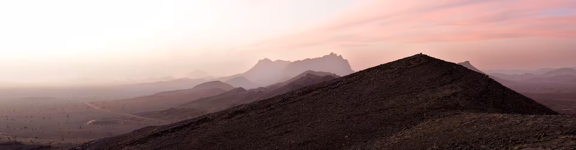 Sunset panorama of rugged desert hills and distant mountains near Alnif, Morocco, gateway to the Sahara and the fossil-rich Jbel Saghro landscapes