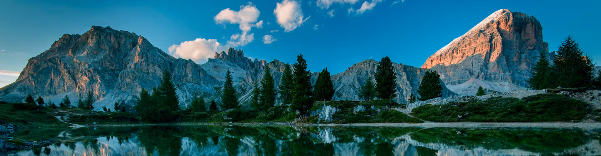 Majestic alpine landscape of Cortina d'Ampezzo with stunning mountain peaks reflected in a tranquil lake, perfect for hiking and nature enthusiasts in the Dolomites.
