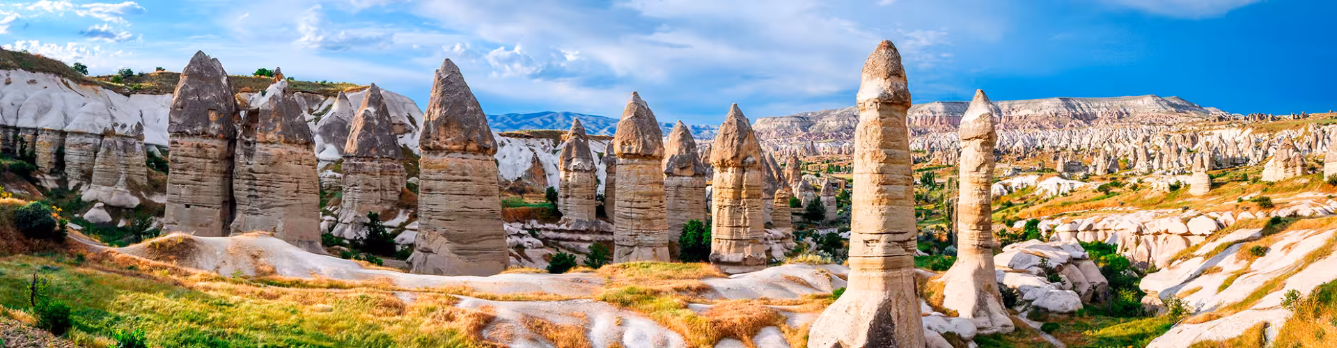 Stunning panoramic view of the unique fairy chimneys in Cappadocia's Göreme National Park, showcasing the captivating geological formations and vibrant landscape.