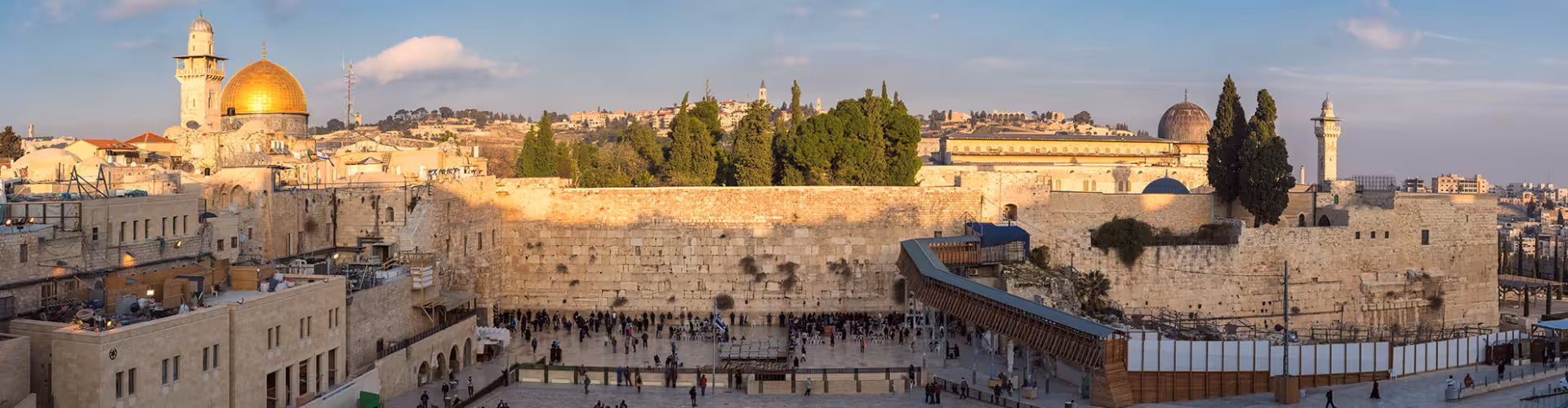 Panoramic view of Jerusalem Old City in Israel featuring the Western Wall and the Dome of the Rock at sunset, a top Holy Land travel and pilgrimage destination.