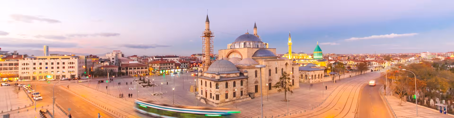 Sunset panoramic view of Konya Province city center with Alaeddin Mosque, Mevlana Museum green dome and modern tram line in Konya, Türkiye