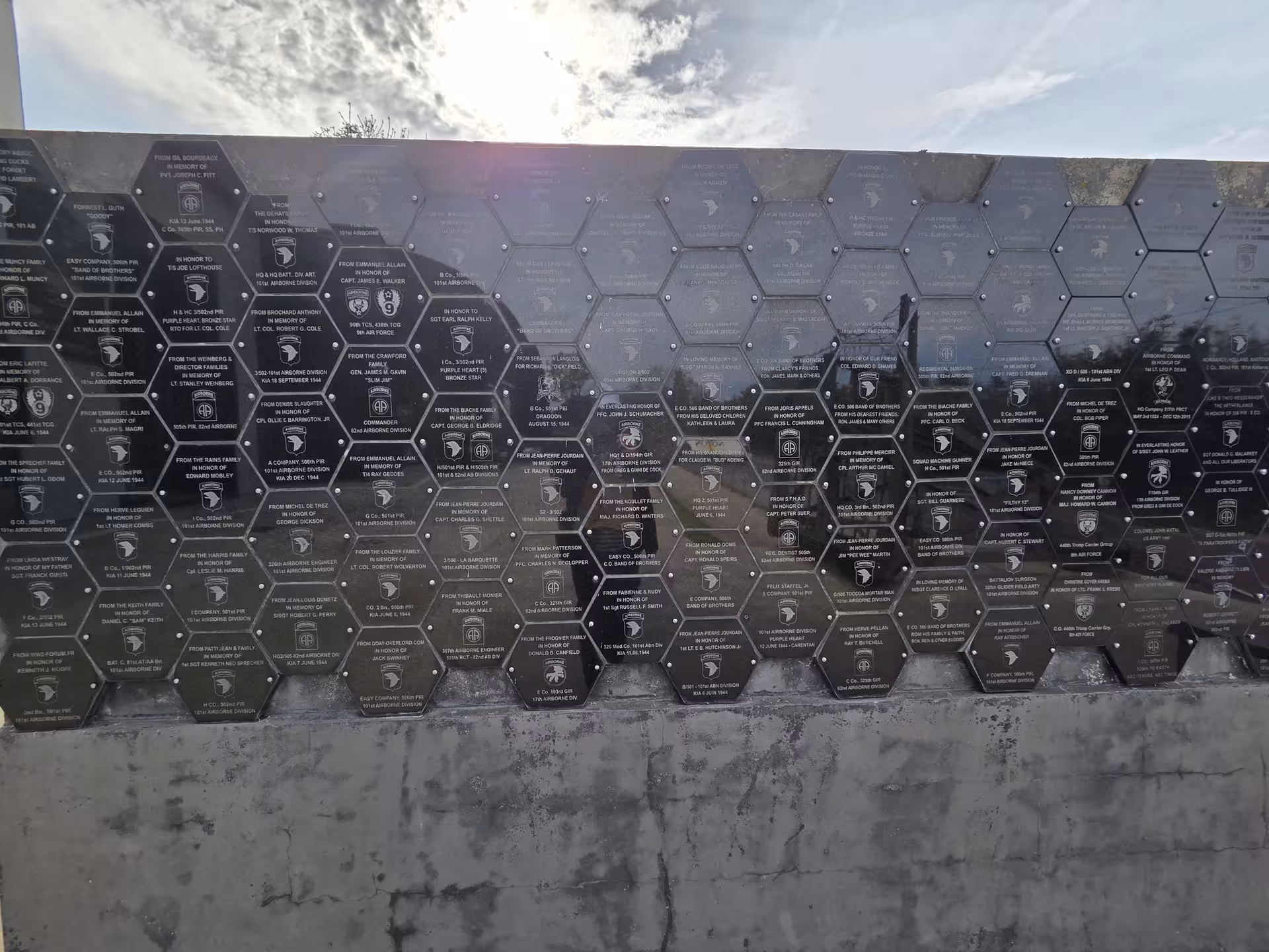 Hexagonal memorial plaques honoring 101st Airborne Division soldiers at a Normandy D-Day guided tour site