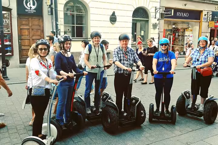 Group of six people enjoying a 120 min Old Town Segway Tour in Krakow, exploring vibrant city streets.