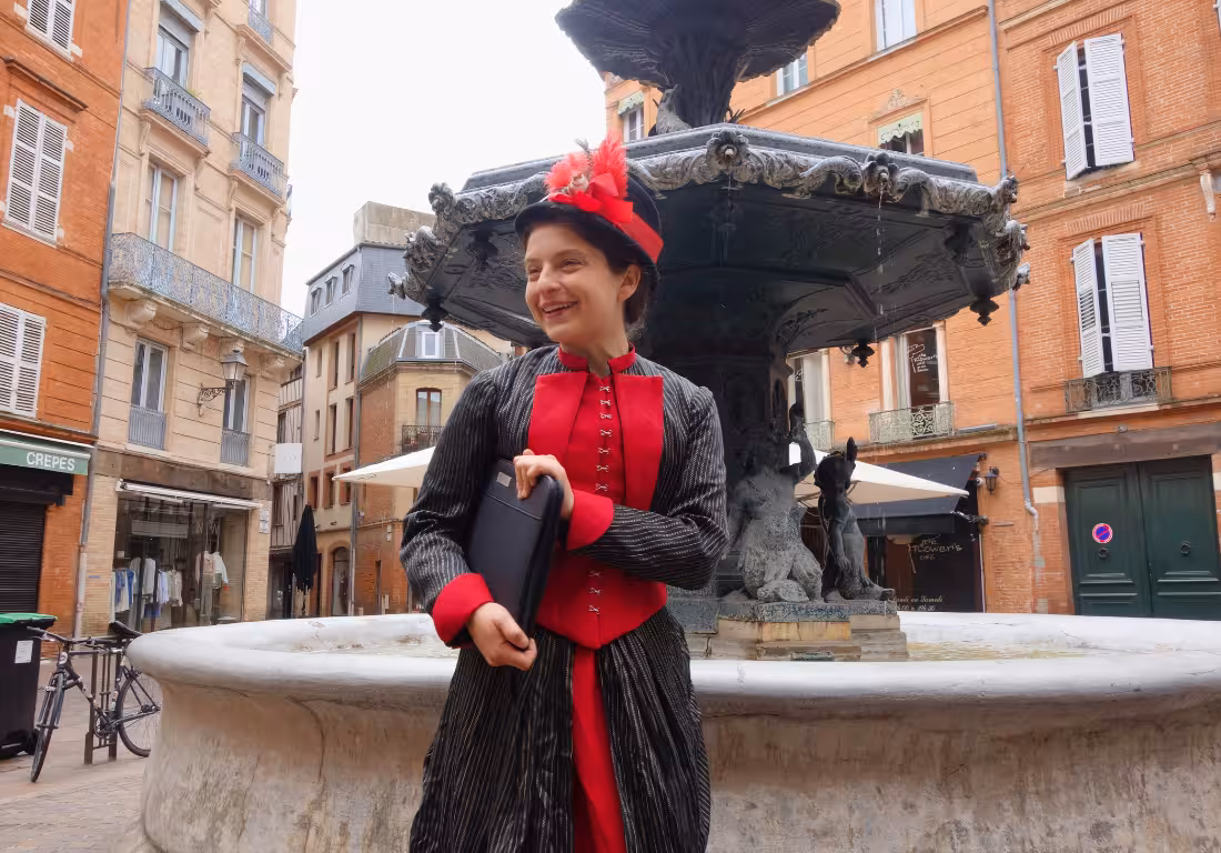 Guide in 19th-century costume by ornate fountain in Toulouse Saint-Georges district