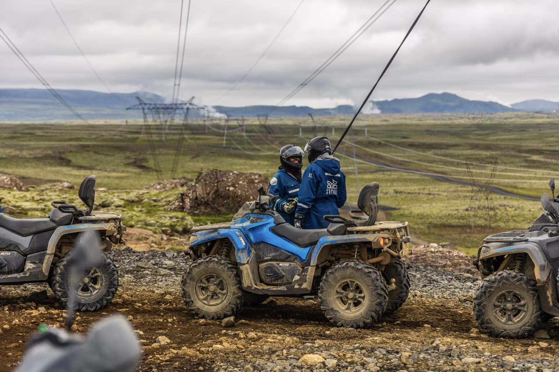 ATV riders pause on a rugged trail with vast landscapes during the 2 Hour Twin Peaks ATV adventure tour, highlighting Iceland's wild beauty.