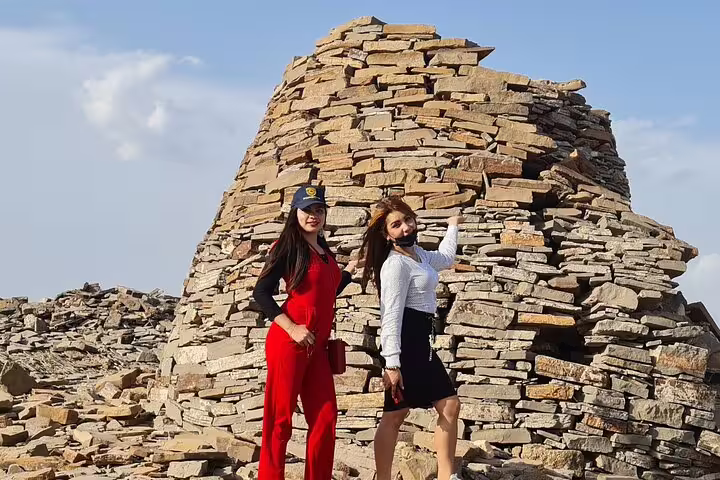 Visitors exploring ancient stone structures on a sunny day during a 3-day private tour in Oman.
