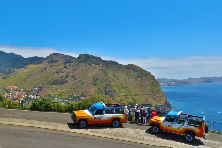 4x4 vehicles parked with tourists enjoying stunning coastal views on a private adventure tour in Madeira's scenic landscape.
