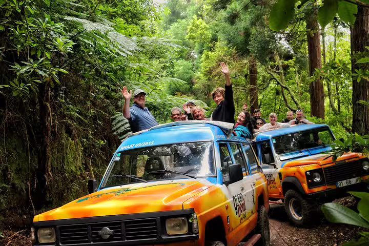 Adventurers enjoy a vibrant 4x4 tour through lush West Madeira forests, showcasing excitement and natural beauty with a local guide.