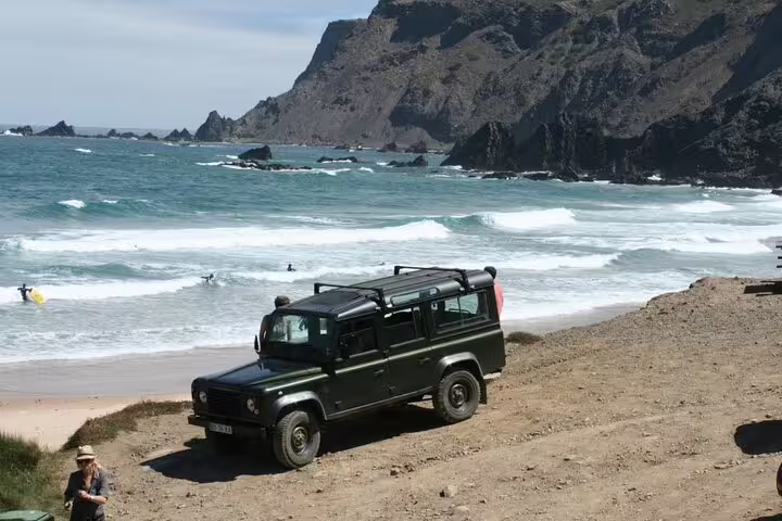 A rugged 4x4 vehicle parked on a scenic beach during the West Coast Natural Park tour, with waves crashing nearby.