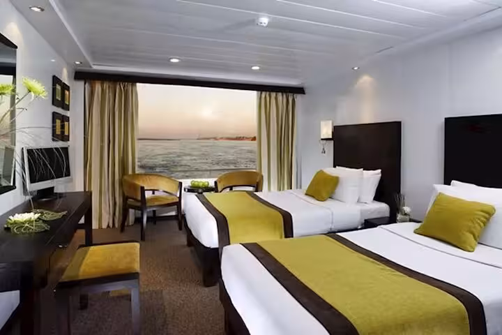5-star deluxe Nile cruise cabin with twin beds and panoramic river view on private Luxor to Aswan tour