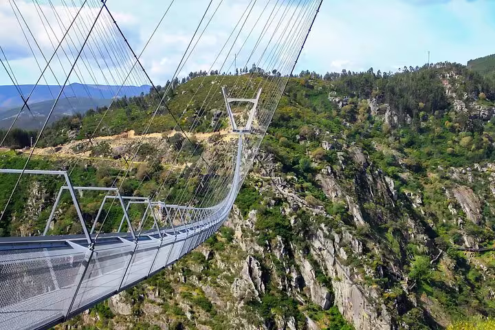 Close-up of the 516 Arouca Suspension Bridge stretching over a deep gorge amid verdant landscapes in Portugal.