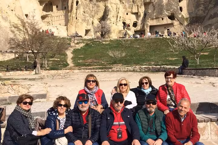 Spanish group tour in Cappadocia with rock-cut cave dwellings backdrop on 6-day Istanbul Cappadocia tour