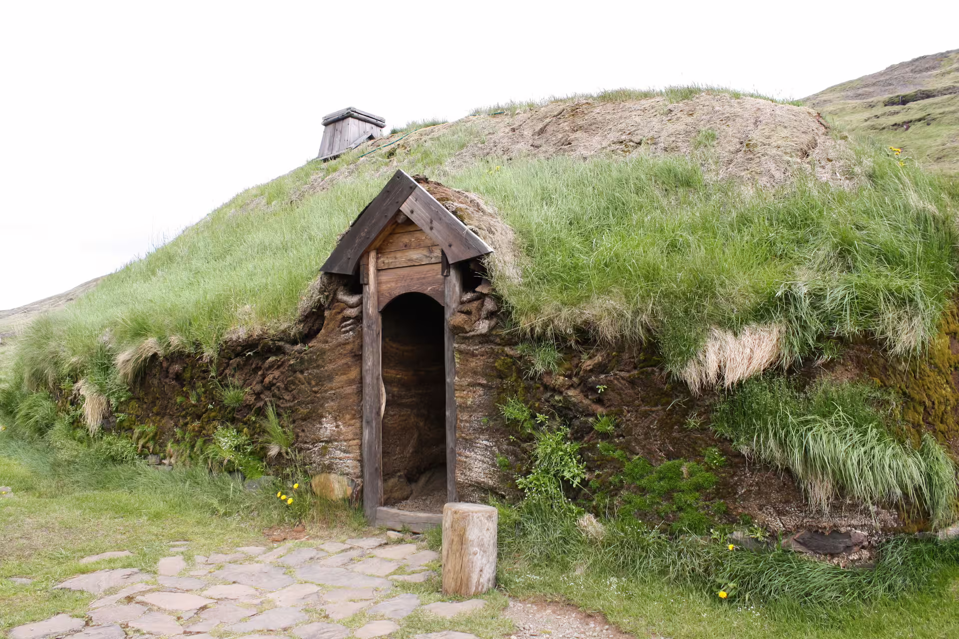 Ancient Icelandic Viking turf house with grass roof and wooden door on the Land of Sagas and Eddas heritage tour