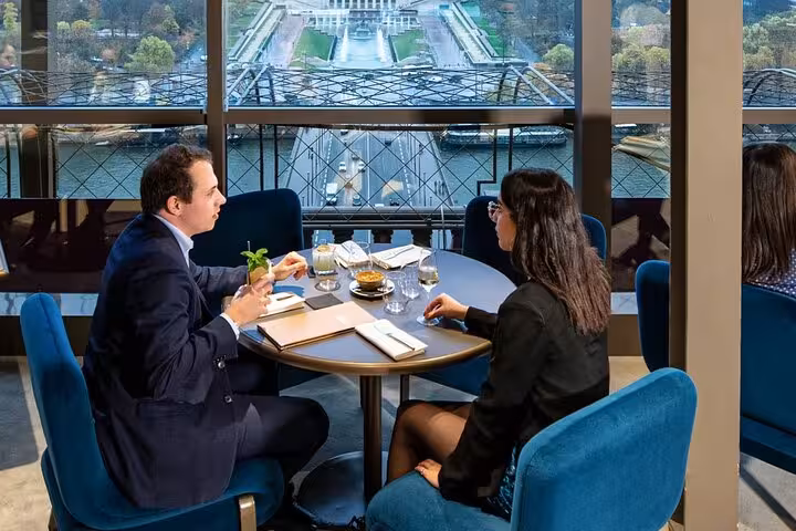 Couple enjoying Eiffel Tower restaurant lunch with Seine view, Paris dining experience with upgrades