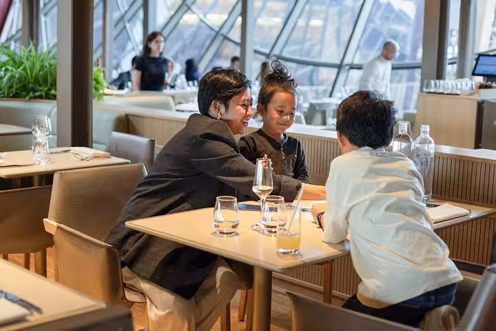 Family enjoying lunch at the Eiffel Tower restaurant during a Paris dining experience with upgrade options