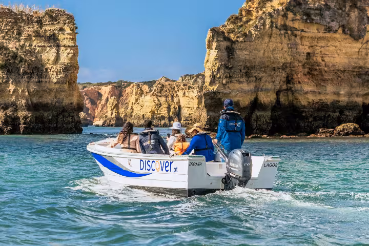 Discover.pt skiff boat tour navigating through Ponta da Piedade golden sea caves and cliffs in Lagos Algarve Portugal