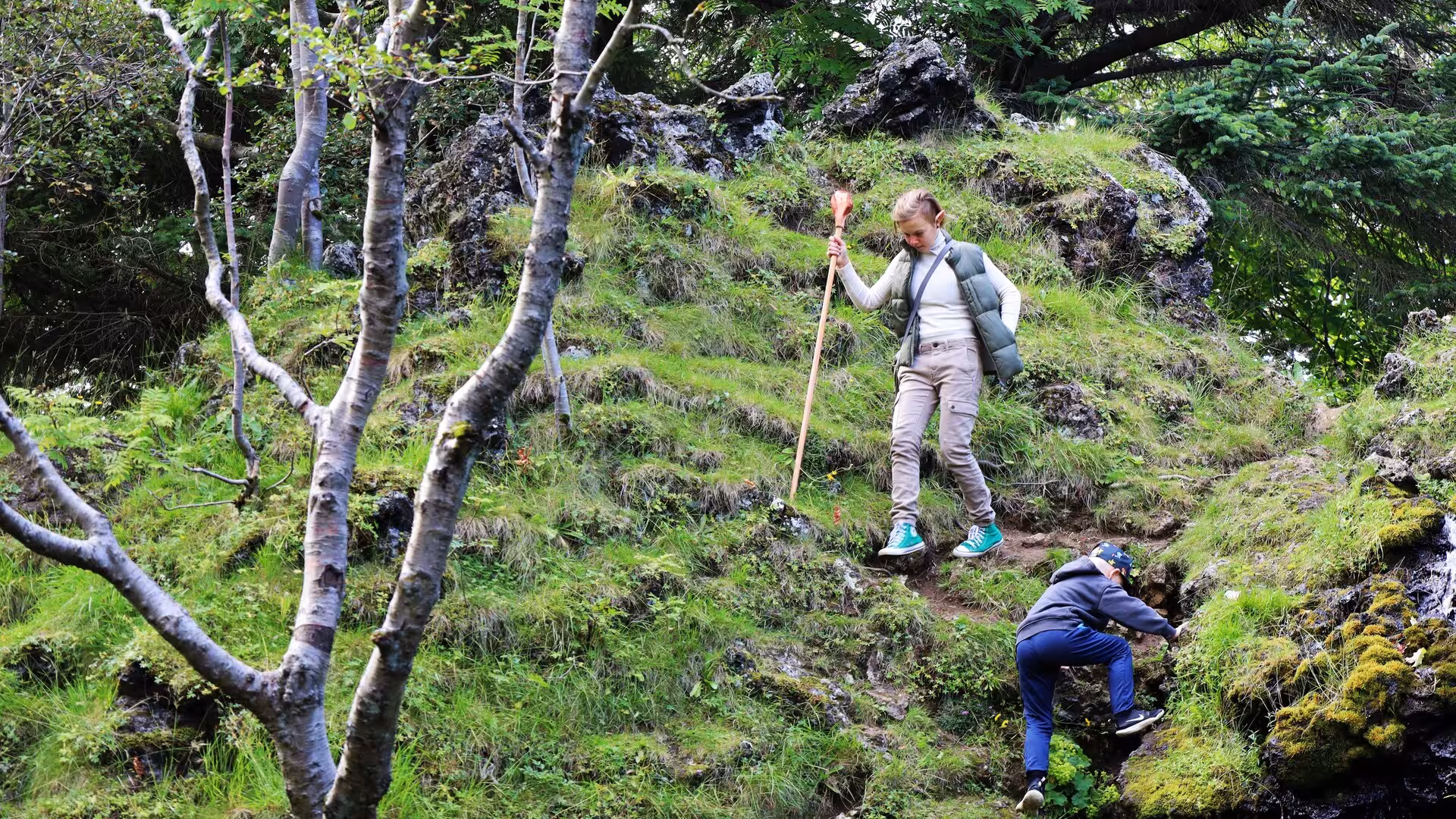 Children exploring mossy lava rock trails on a Reykjavik Elves and Nature guided driving tour in Iceland