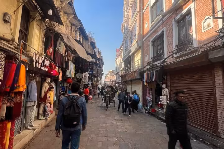 Hand holding a smartphone displaying the Kathmandu Durbar Square self-guided GPS walking tour app with interactive map