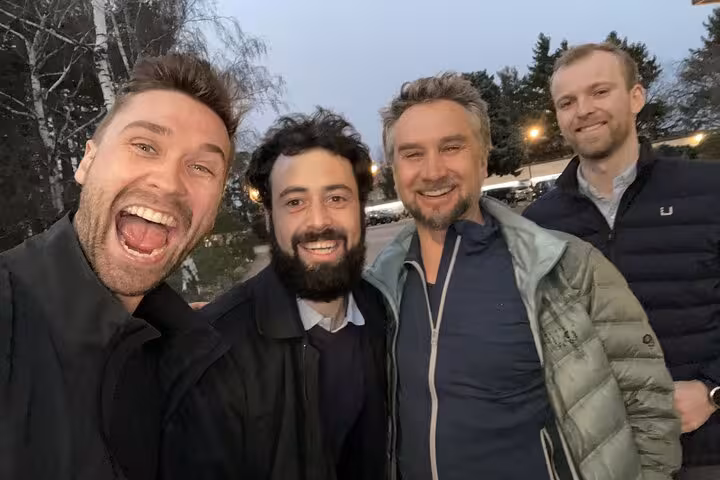 Group of four men laughing outdoors at dusk enjoying the Lyon self-guided haunted ghost hunt walking tour experience.
