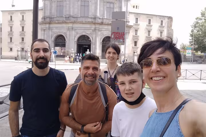 Happy family group smiling in front of historic Madrid church during self-guided Escape the Inquisition walking tour.