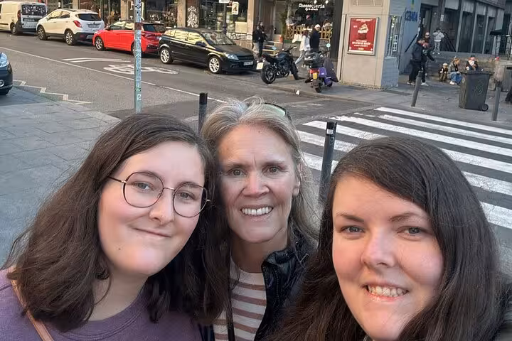 Three happy tourists taking a selfie on a lively Madrid street during a self-guided Escape the Inquisition walking tour.