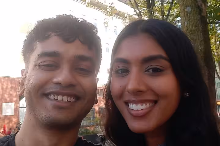 A smiling couple enjoying a self-guided escape game and scavenger hunt adventure outdoors in Amsterdam.