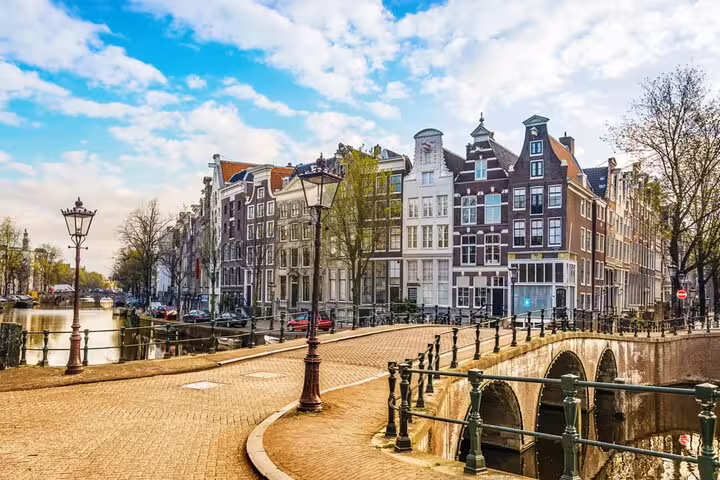 Scenic Amsterdam canal with historic Dutch gabled houses perfect for a self-guided escape game adventure.