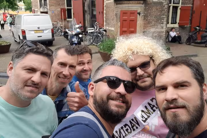 A cheerful group of friends enjoying a self-guided escape game scavenger hunt adventure in Amsterdam streets.