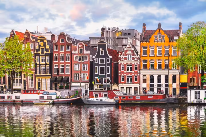 Colorful Amsterdam canal houses reflecting in water perfect backdrop for a self-guided escape game scavenger hunt