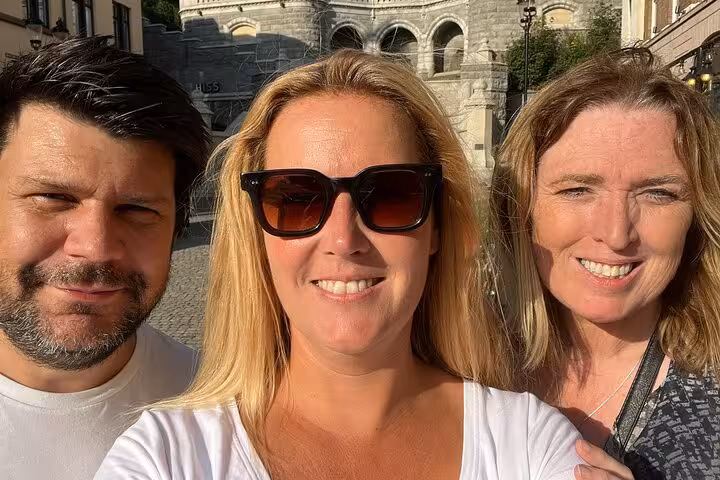 Three friends smiling in selfie near historic Helsingborg Old Town landmark on a self-guided walking tour