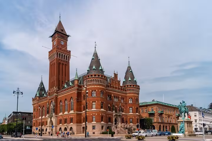 Iconic red-brick Helsingborg City Hall with clock tower and equestrian statue on self-guided walking tour