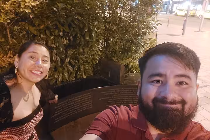 Couple enjoying a fun Budapest self-guided detective mystery quest night walk, posing at a historic city landmark.