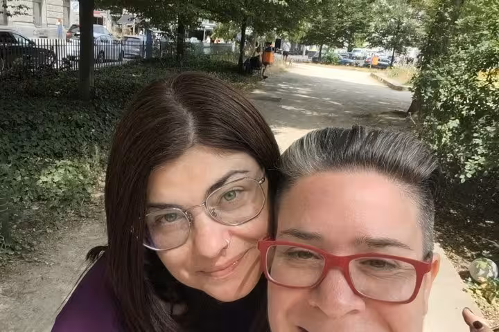 Two tourists smiling in a Berlin park while enjoying a WW2 self-guided smartphone walking tour