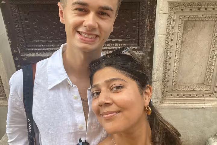 Smiling couple posing at a historic Pisa landmark during a self-guided mystery puzzle adventure tour