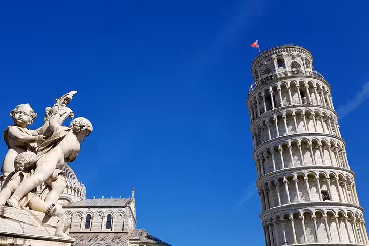 Iconic Leaning Tower of Pisa with cherub statue under blue sky on self-guided mystery puzzle walking tour