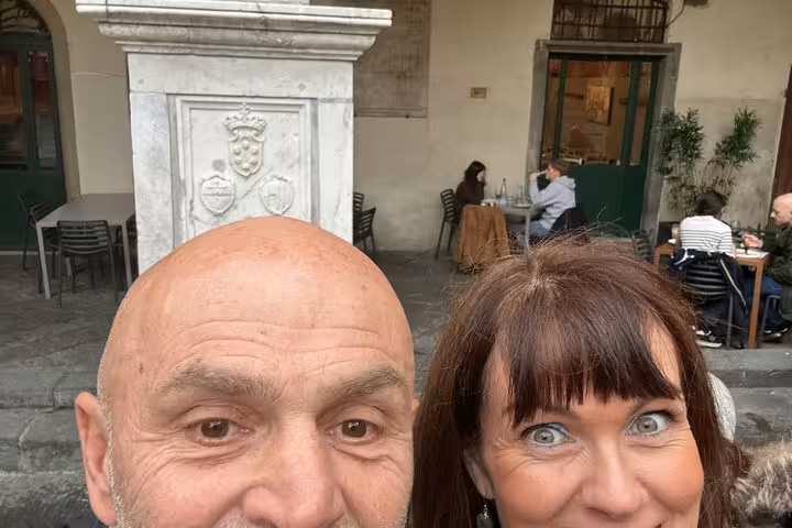 Couple posing at historic Pisa piazza marble monument during fun self-guided mystery puzzle walking tour