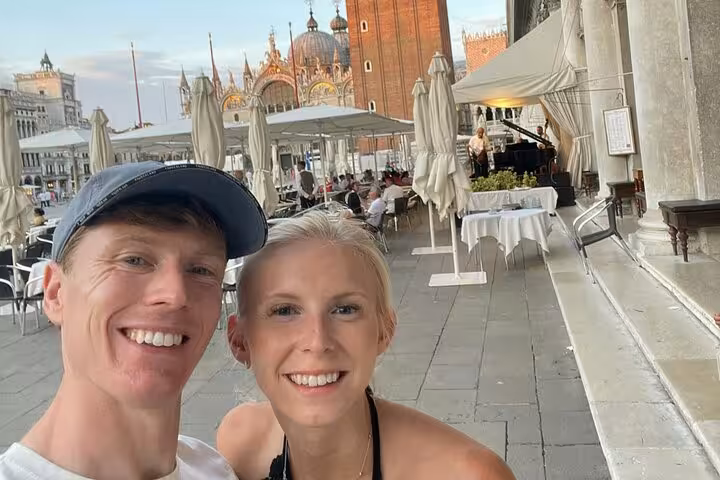 Happy couple taking a selfie at St. Marks Square Venice enjoying a self-guided romance game tour