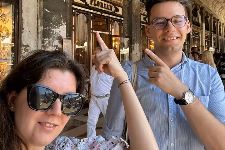 Couple pointing at historic Cafe Florian in Venice during a fun self-guided Casanova romance walking game