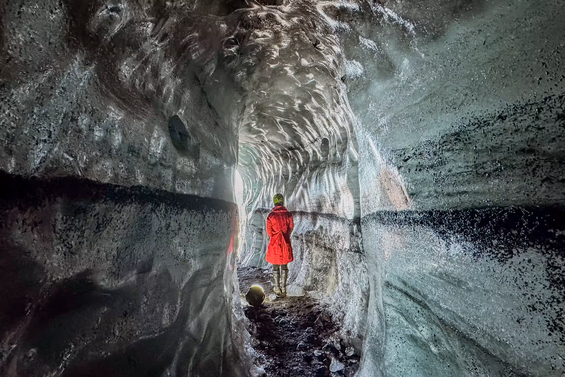 Excited traveler posing inside stunning Katla ice cave on Myrdalsjokull glacier day trip from Vik Iceland